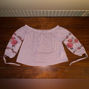 American eagle size medium light purple top with flowers embroidered on sleeves.